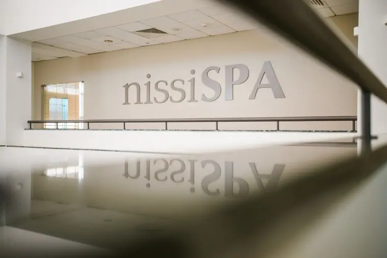Nissi Spa sign reflected in a glossy reception desk