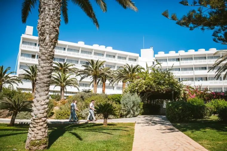 Palm-lined garden path leading to the white hotel blocks at Nissi Beach Resort