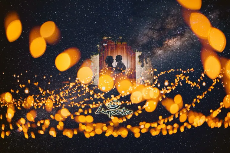 Couple in a lit doorway under the Milky Way framed by fairy-light bokeh at Liopetro, Kouklia