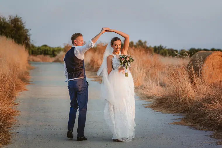 Charlene and Ben dancing on a path through golden grasses at Liopetro, Kouklia